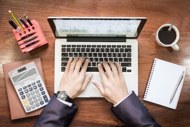 Business owner comparing website costs on a laptop and tablet at a wooden desk