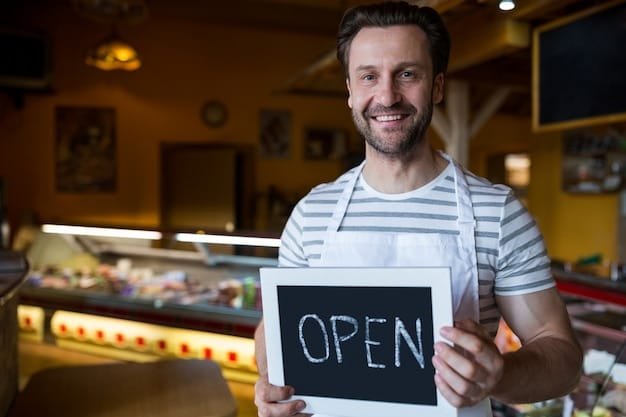 Smiling small business owner holding an open sign at their shop